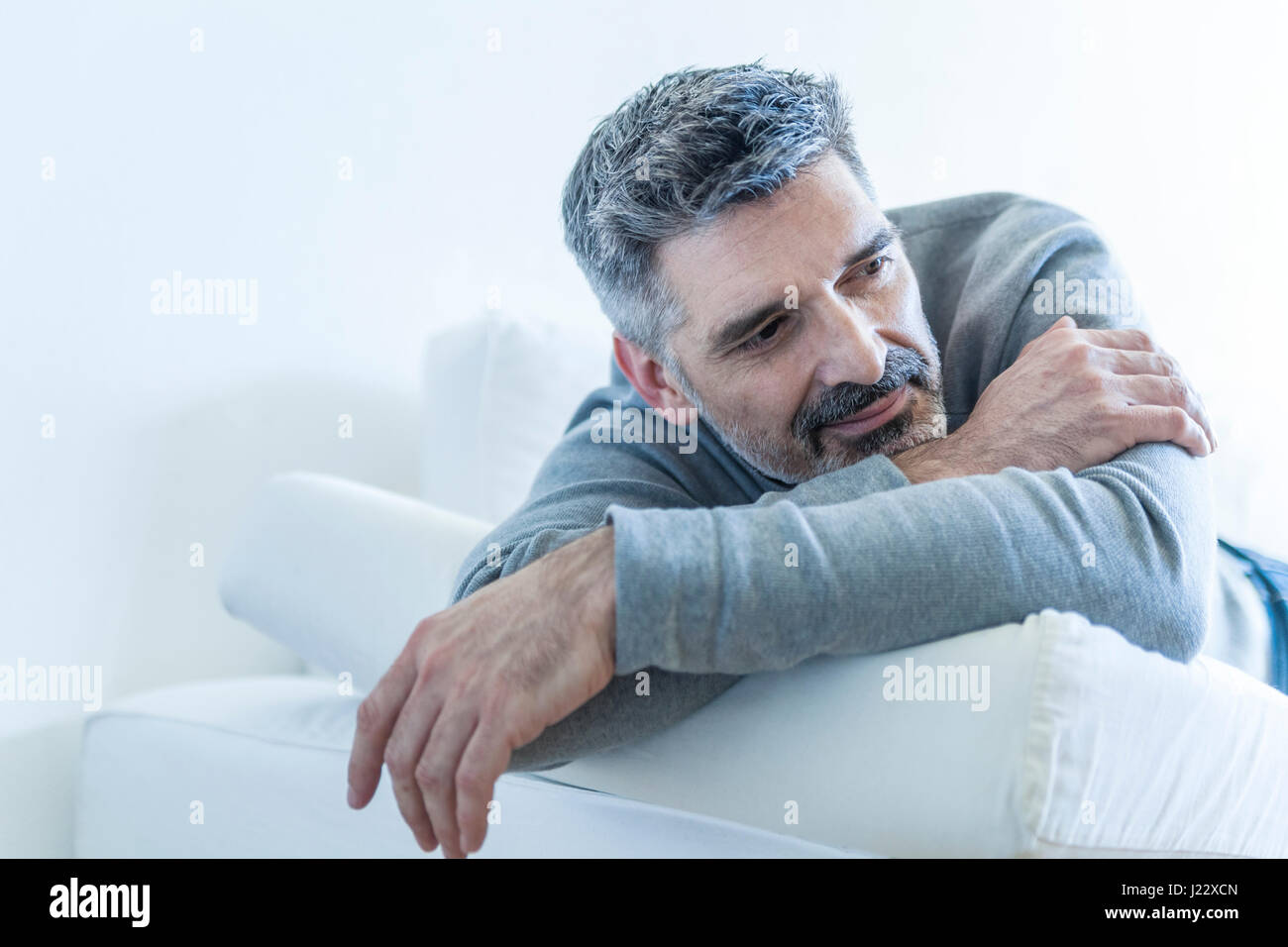 Relaxed mature man at home lying on couch Stock Photo - Alamy
