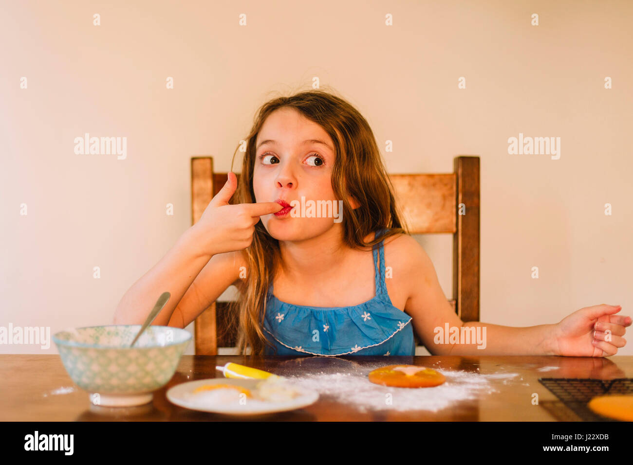 Portrait of girl decorating biscuits at home Stock Photo