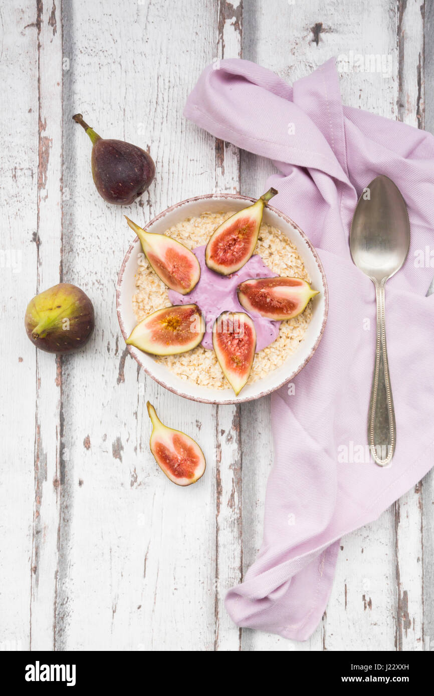 Bowl of overnight oats with blueberry yoghurt and figs on wood Stock Photo