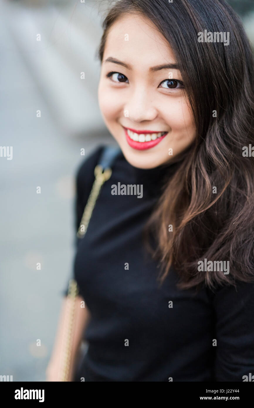 Portrait of smiling young woman dressed in black Stock Photo - Alamy