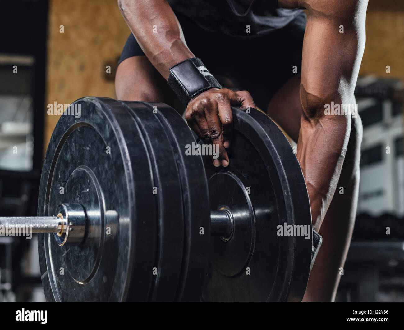 Athlete in gym doing weight lifting Stock Photo
