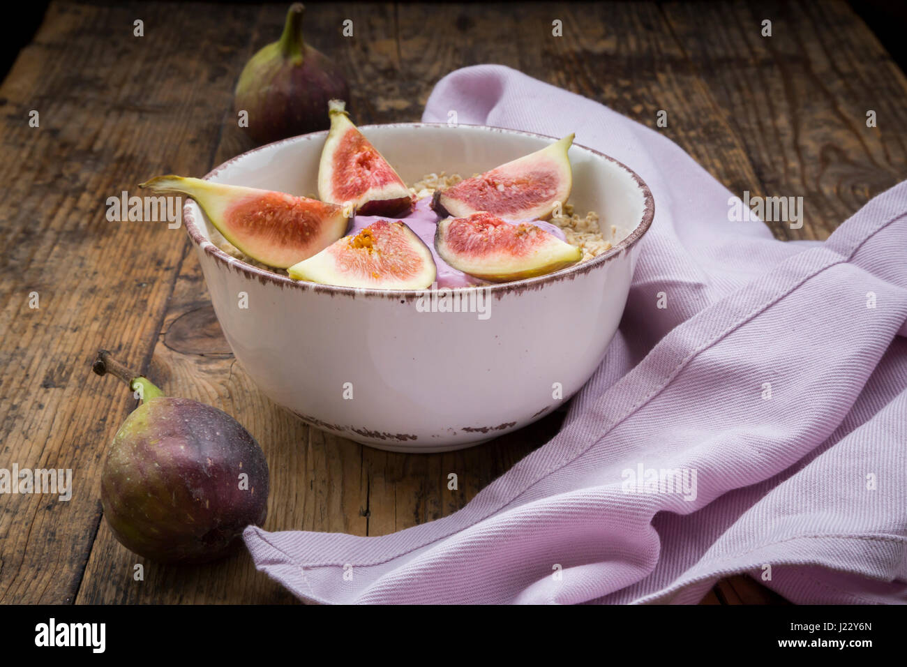 Bowl of overnight oats with blueberry yoghurt and figs on wood Stock Photo