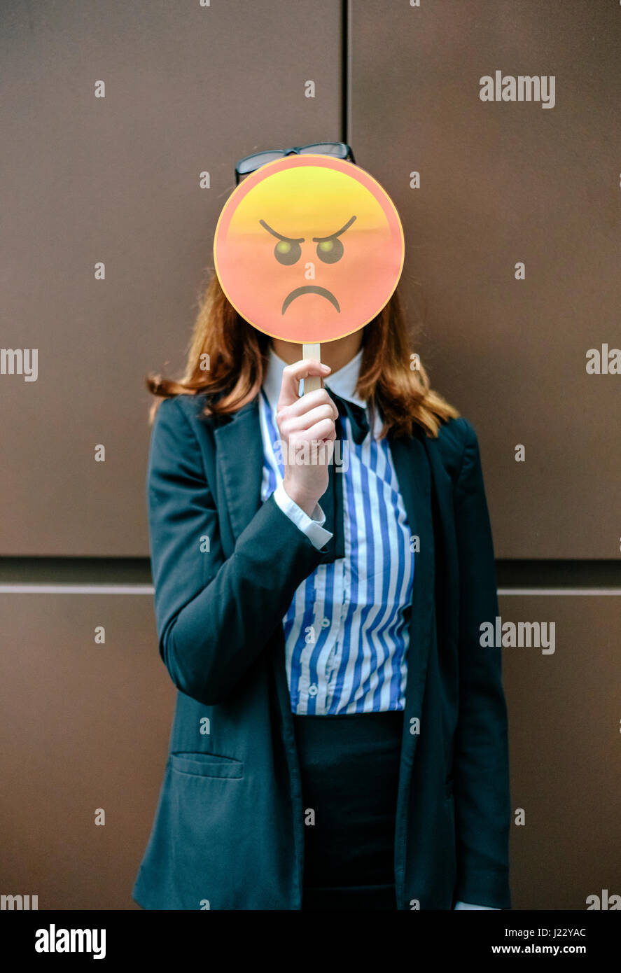Woman hiding face behind emoji mask Stock Photo Alamy