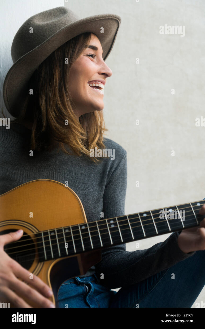 Happy young woman playing guitar Stock Photo - Alamy