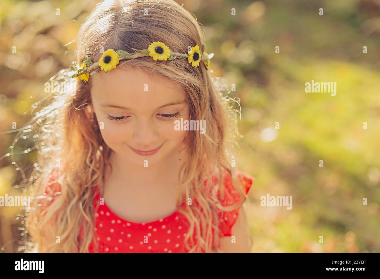 Portrait of smiling little girl wearing flower wreath Stock Photo
