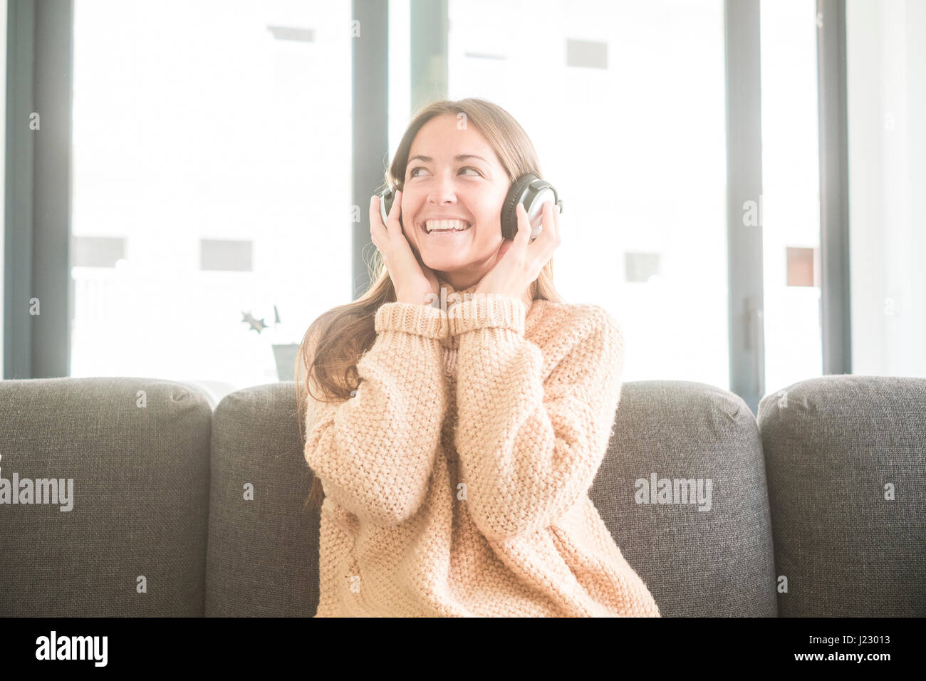 Happy young woman listening to music at home Stock Photo - Alamy