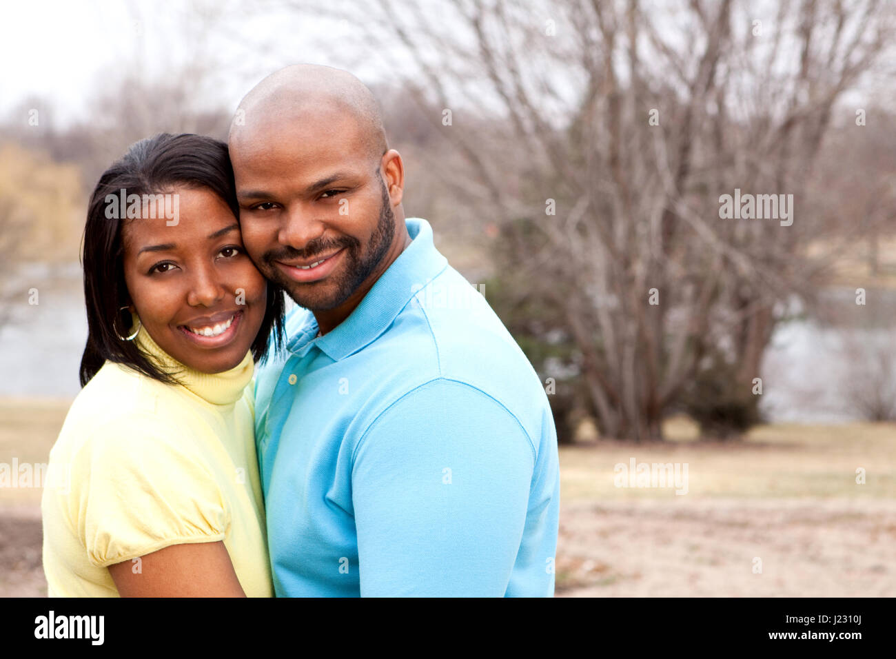 Loving happy African American couple hugging and smiling Stock Photo ...