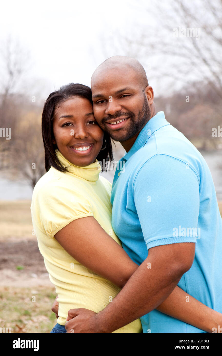 Loving happy African American couple hugging and smiling Stock Photo ...