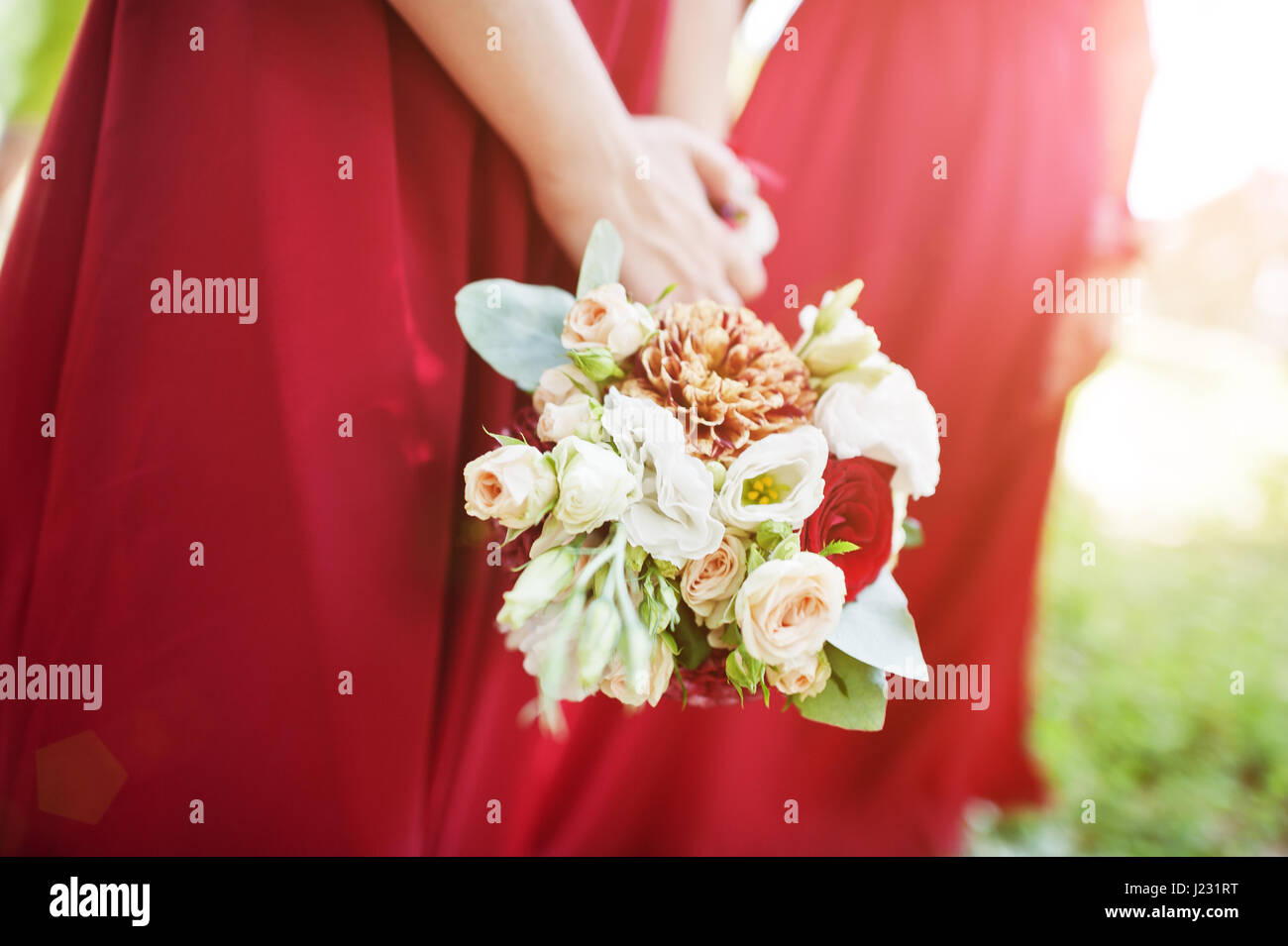 Hands of two bridesmaids wear on red dress with wedding bouquets Stock ...