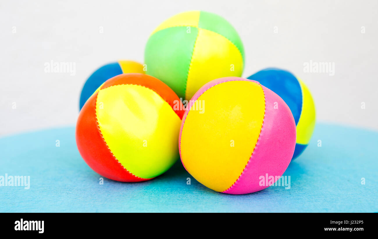 stack of colorful juggling balls on blue table with white background ...