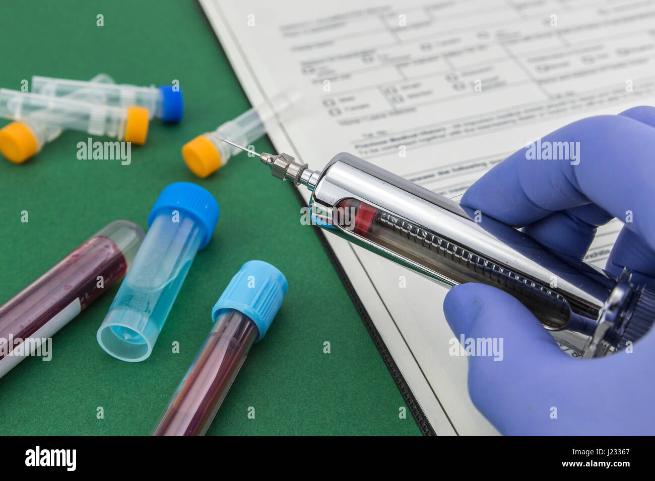 Scientist with blue latex gloves holds syringe special in laboratory for analysis Stock Photo