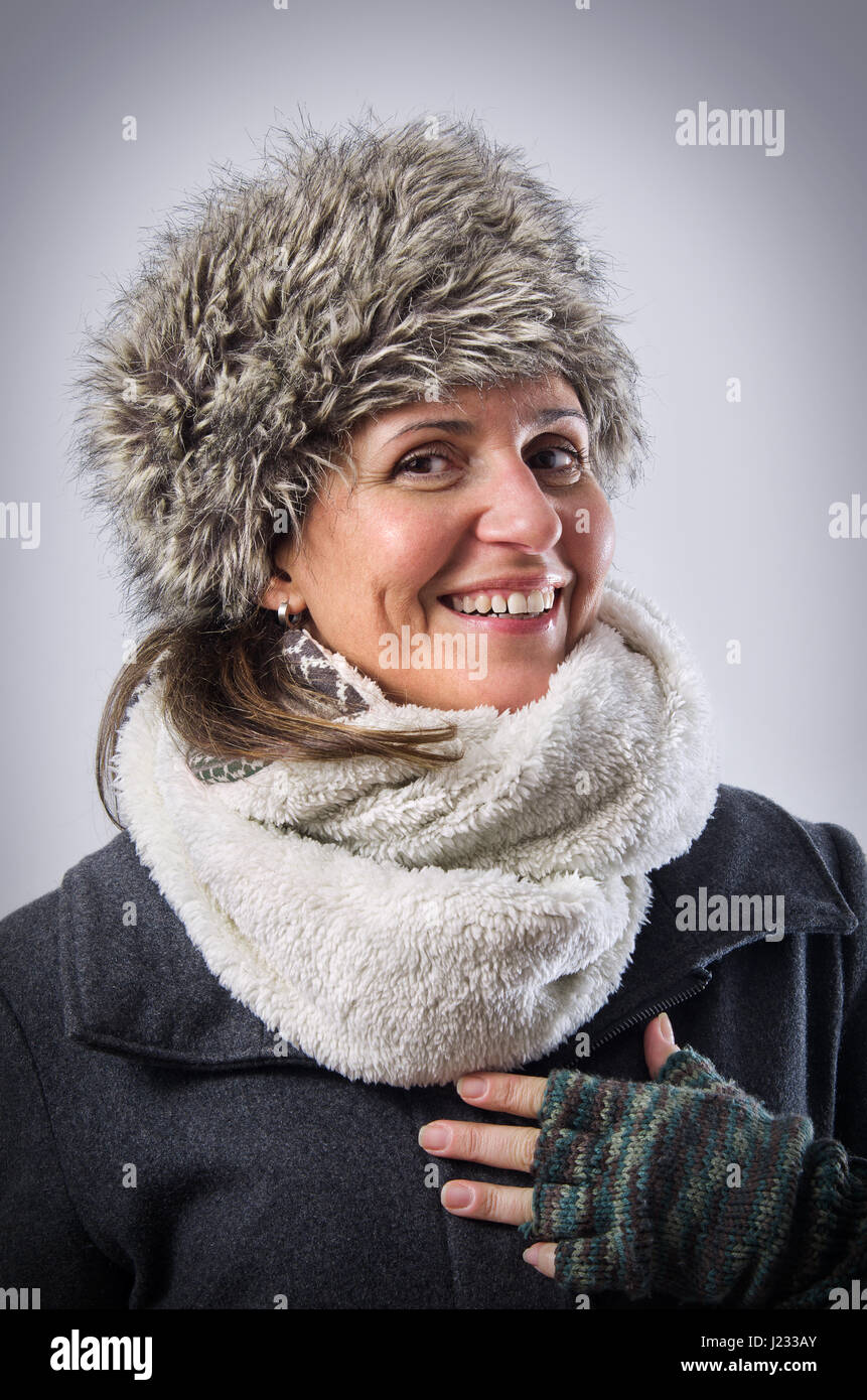 Happy caucasian woman wearing a fur bonnet and warm scarf Stock Photo