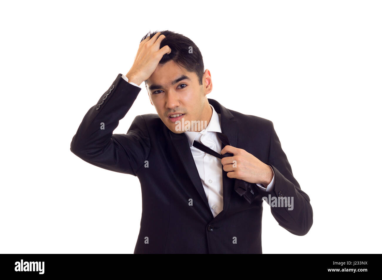 Young man in suit fixing his tie Stock Photo - Alamy