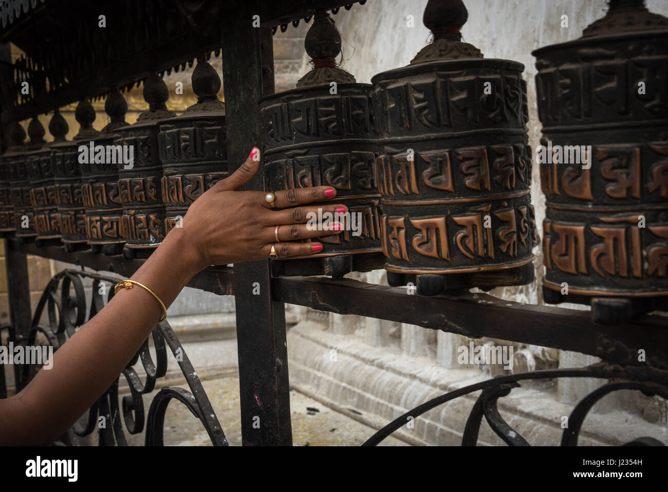 A woman's hand spins the prayer wheels at Swayambhunath Temple in ...