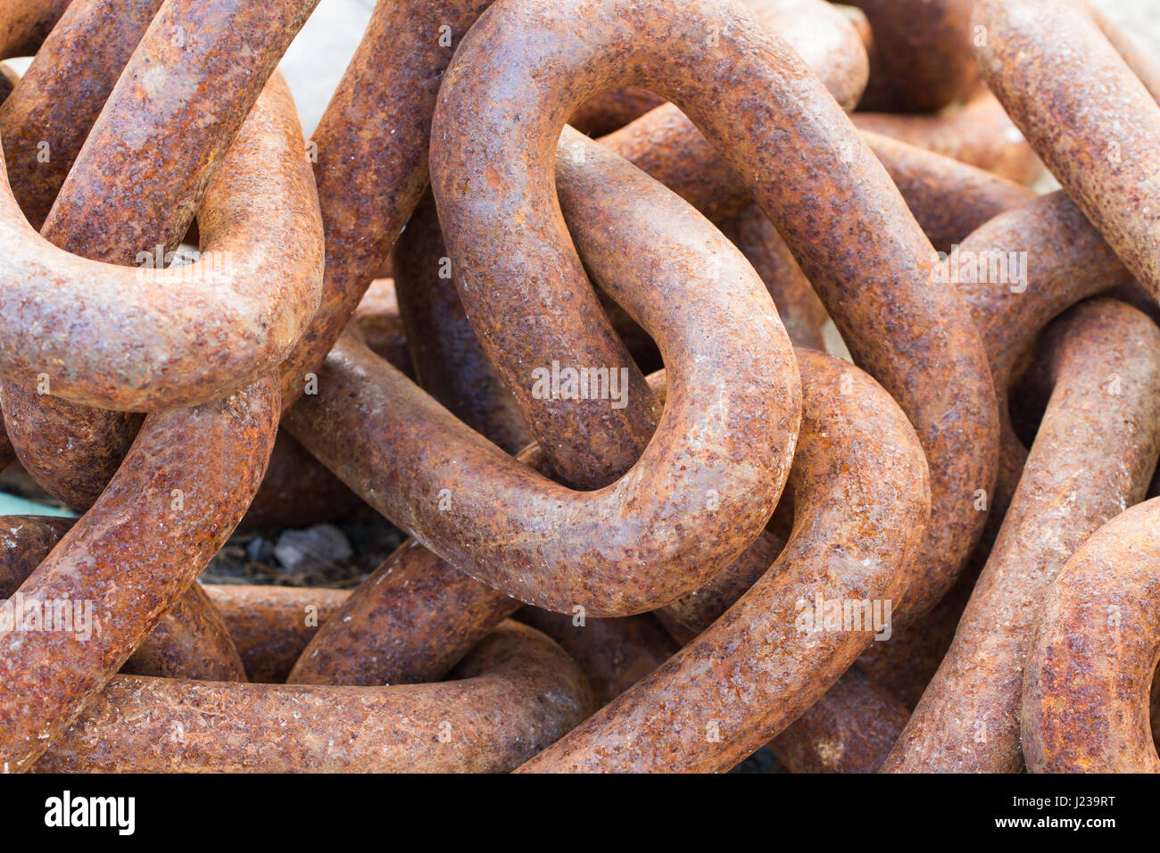 A close up image of thick, heavy metal chains tangled up together and filling the frame in an industrial, background image. Stock Photo