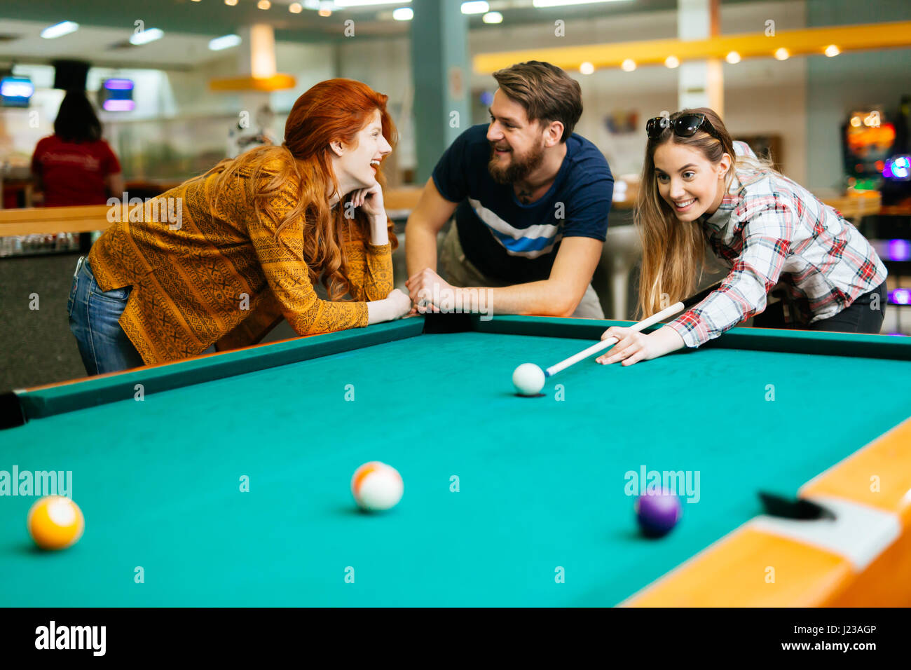 Friends enjoying playing billiards Stock Photo Alamy