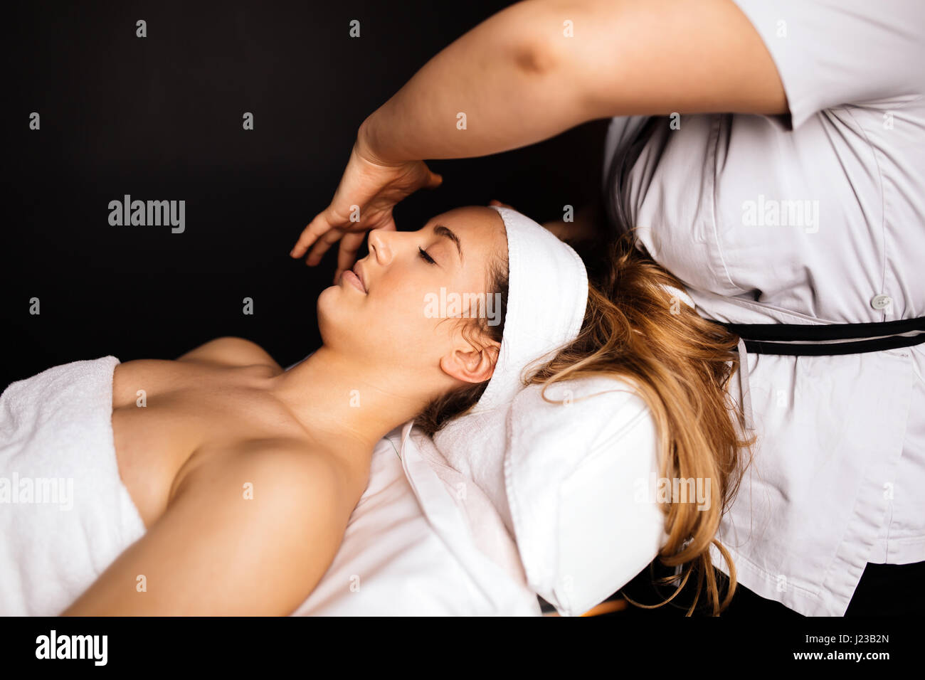 Beautiful woman enjoying massage treatment given by therapist Stock Photo