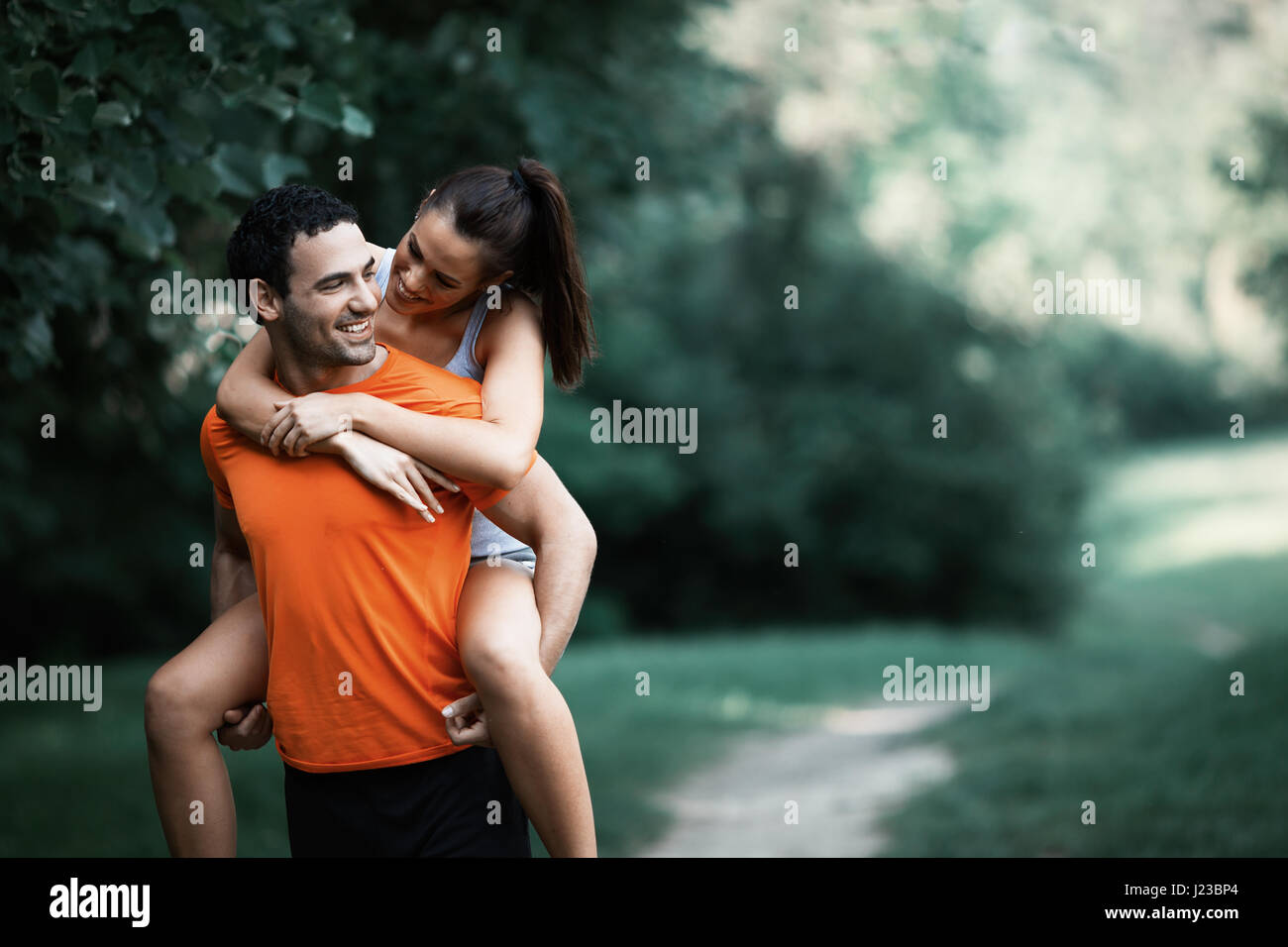 happy sporty couple hacing fun after jogging in nature stock image