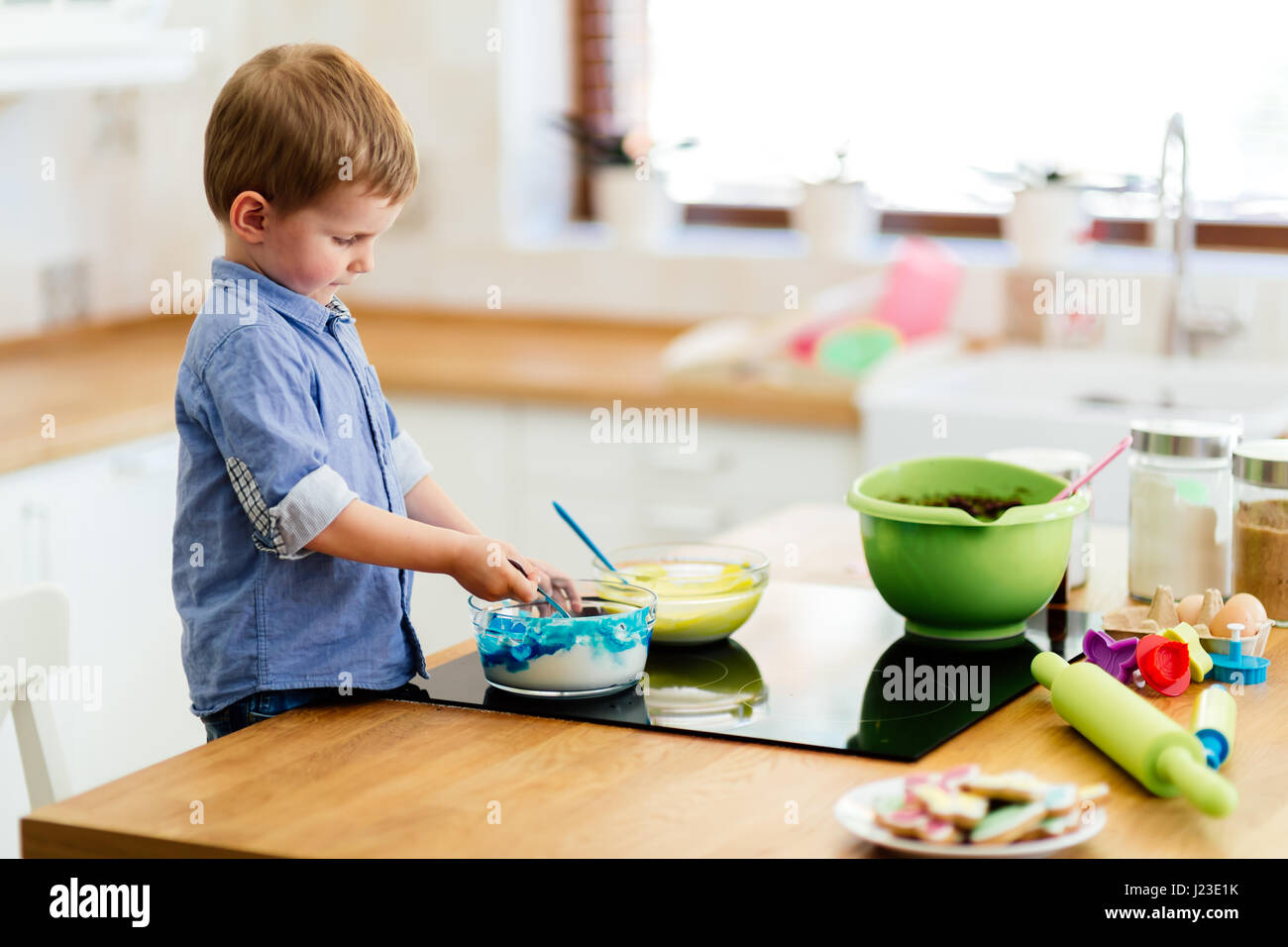 Kid Helping In Kitchen Child helping out in kitchen with the making of muffins Stock Photo - Alamy