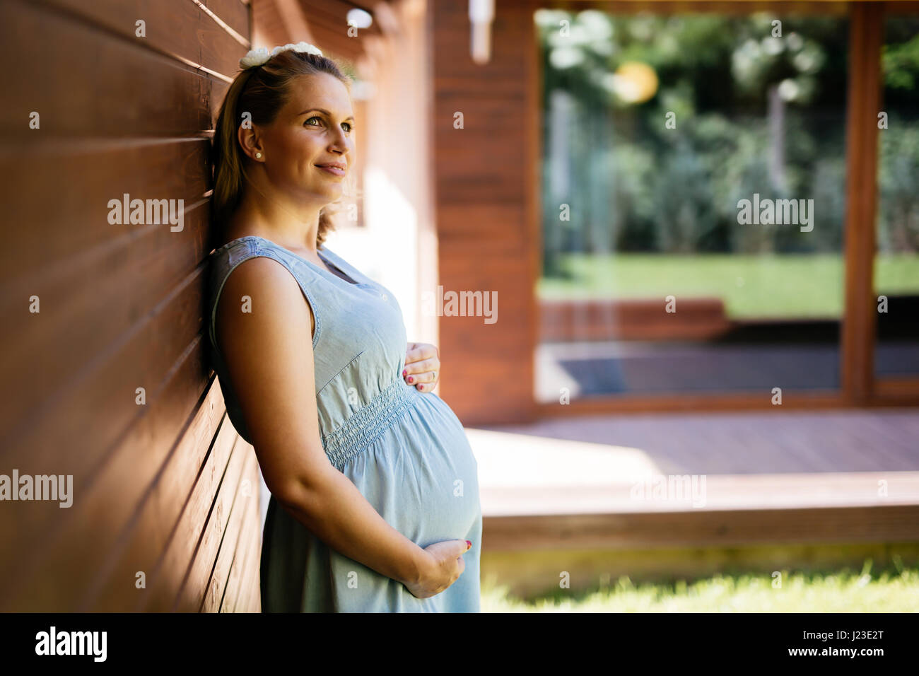 Beautiful blond pregnant woman holding her belly Stock Photo