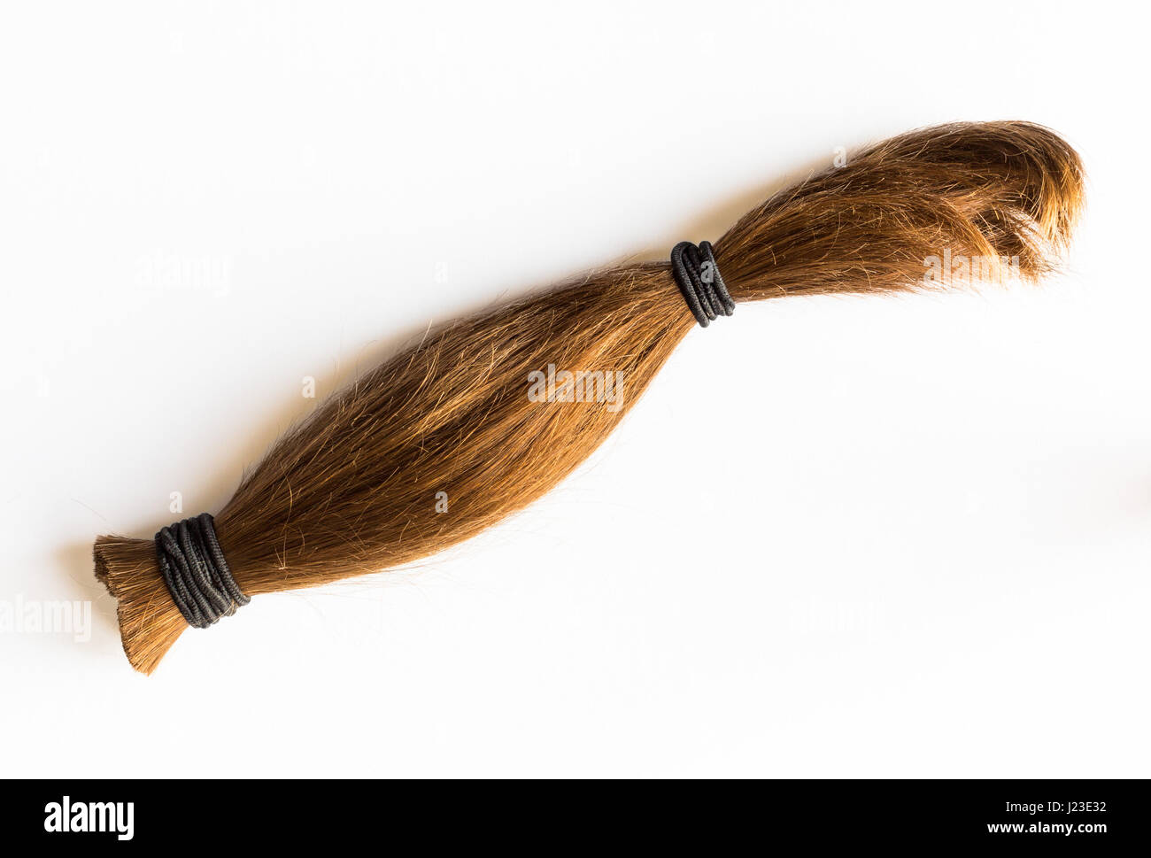 Cut length of human brown hair tied to make wigs Stock Photo