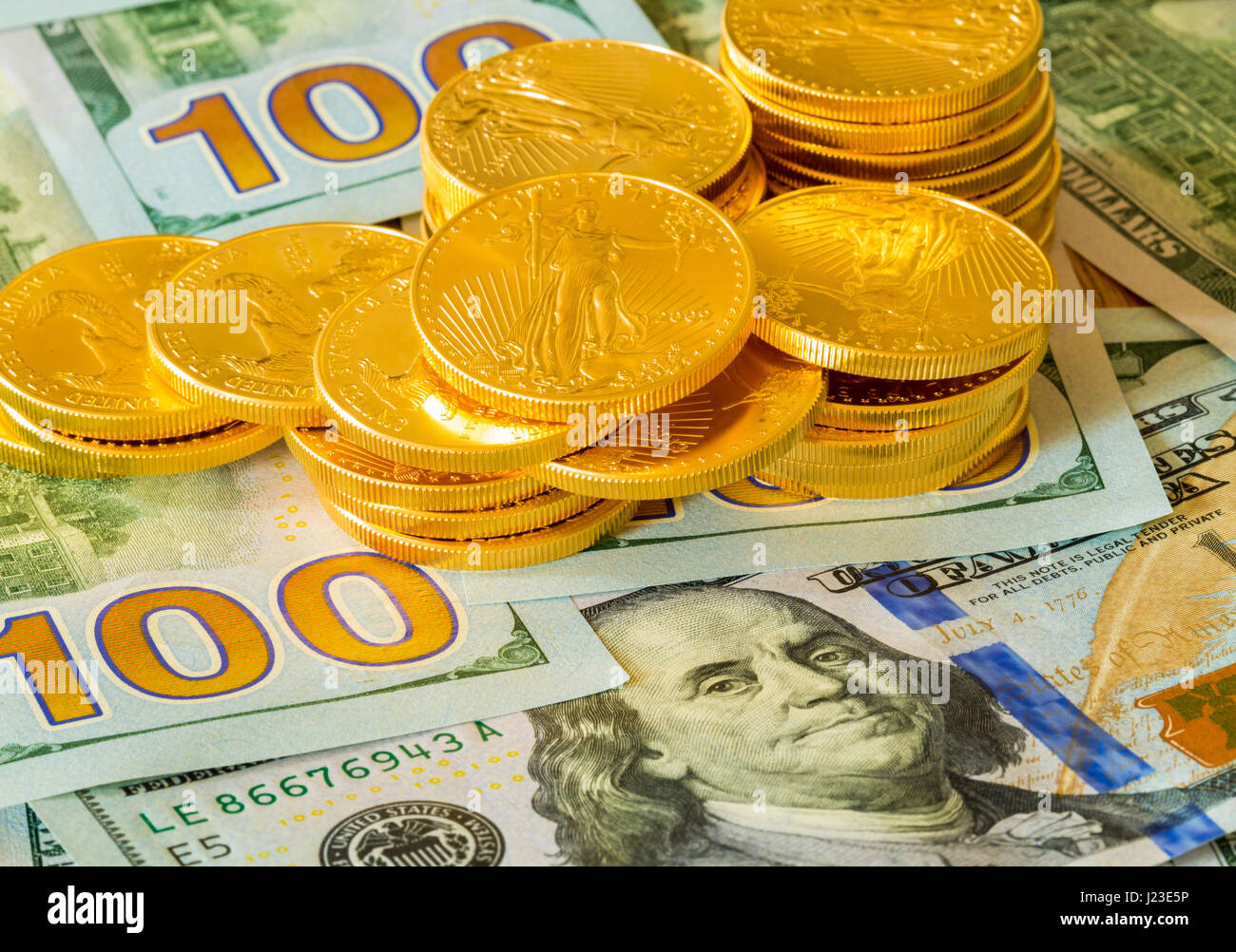 Stack of American gold eagle gold bullion coins on new design of US currency 100 dollar bills Stock Photo