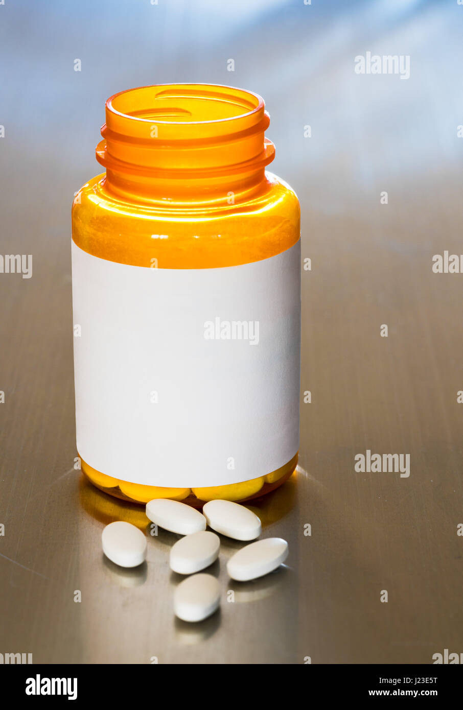Pill bottle with blank label and white pills or tablets Stock Photo