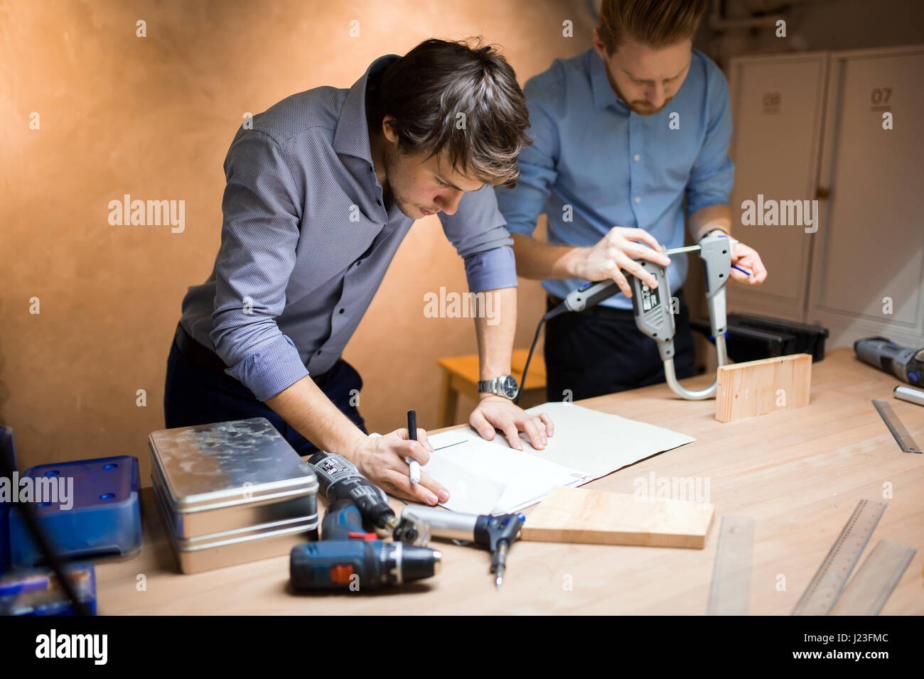 Two designers working together in workshop with precision tools Stock Photo