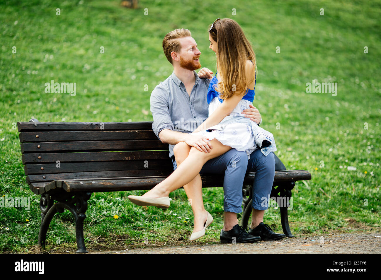 Romantic couple in love sitting on park bench Stock Photo - Alamy