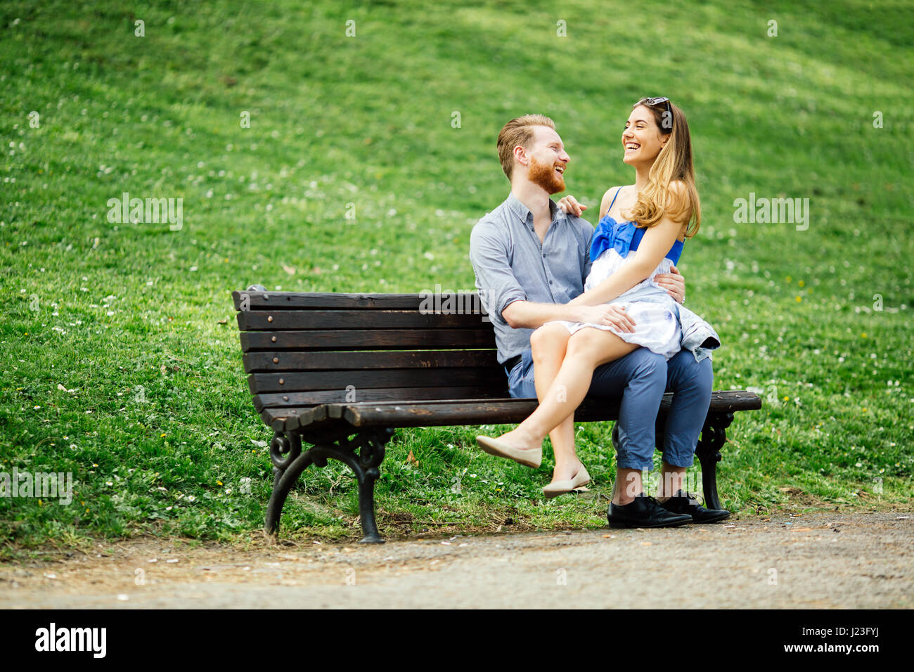 Romantic couple in love sitting on park bench Stock Photo - Alamy