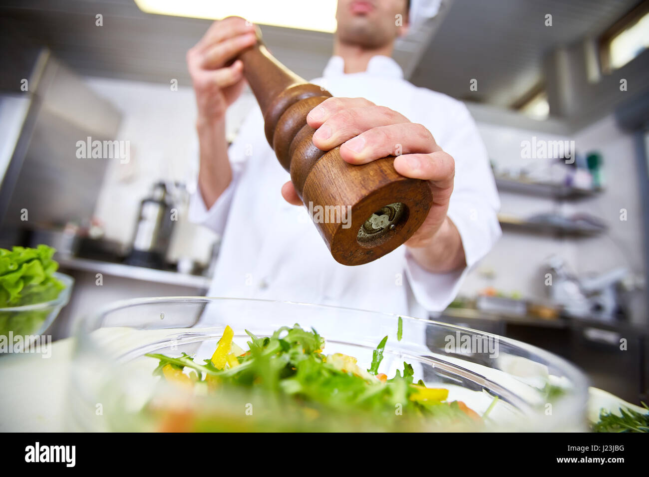Chef seasoning frsh salad with spices Stock Photo