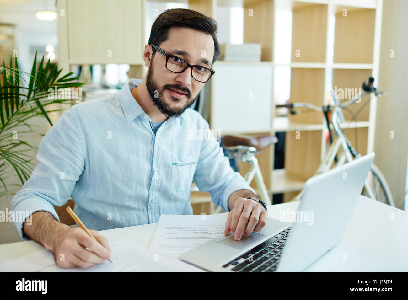 Portrait of confident Asian business man working with laptop in ...