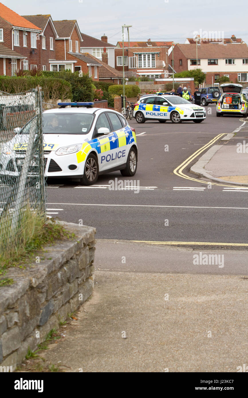 Police cars attending an incident block a suburban road Stock Photo