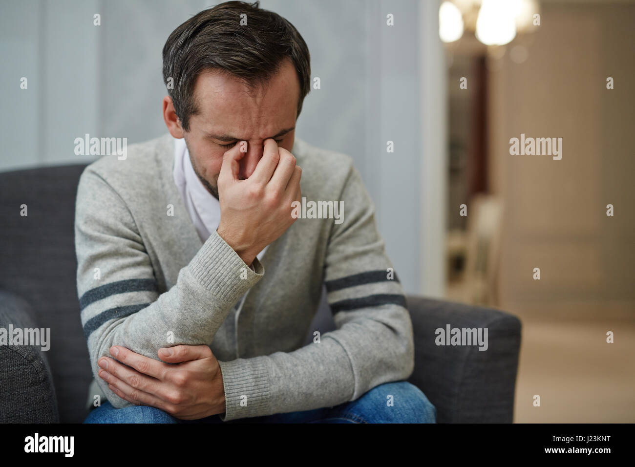 Desperate man crying during psychological session Stock Photo