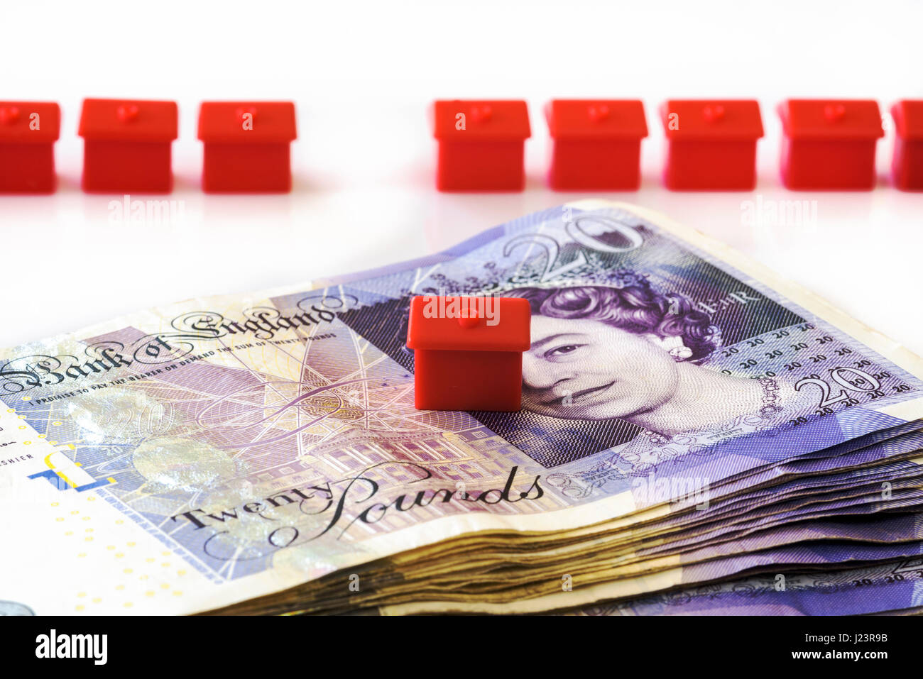 Row of monopoly houses and cash.Trying to get on the property ladder, unaffordable homes. Stock Photo