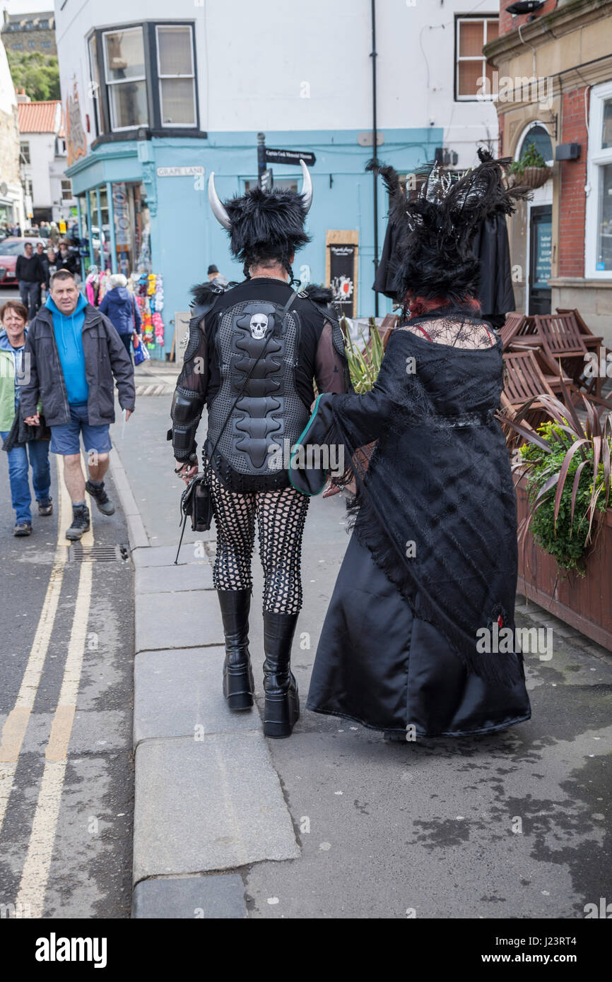 A man and woman dressed as Goths walking through the streets at the Whitby Goth Weekend in North Yorkshire,England,UK Stock Photo