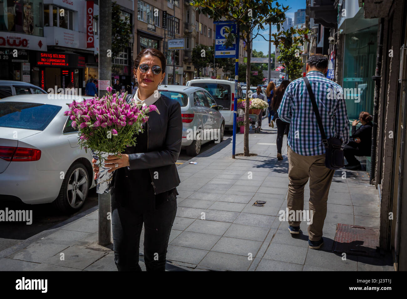 Stylish female with pink flowers in a rich shopping street area of Istanbul, Turkey, Nisantasi in spring Stock Photo