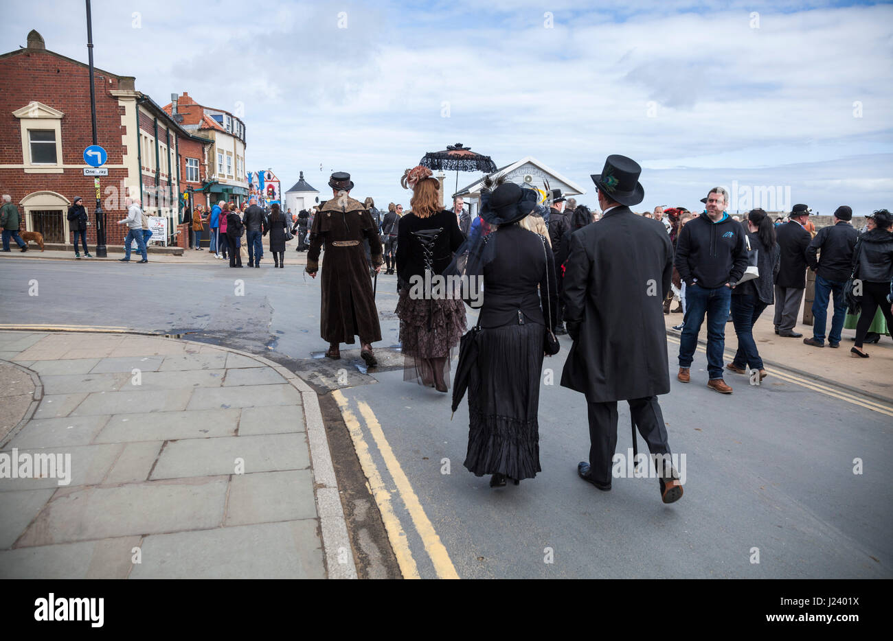 A group of Goths and Steampunks make their way towards the pier at Whitby,North Yorkshire,England Stock Photo