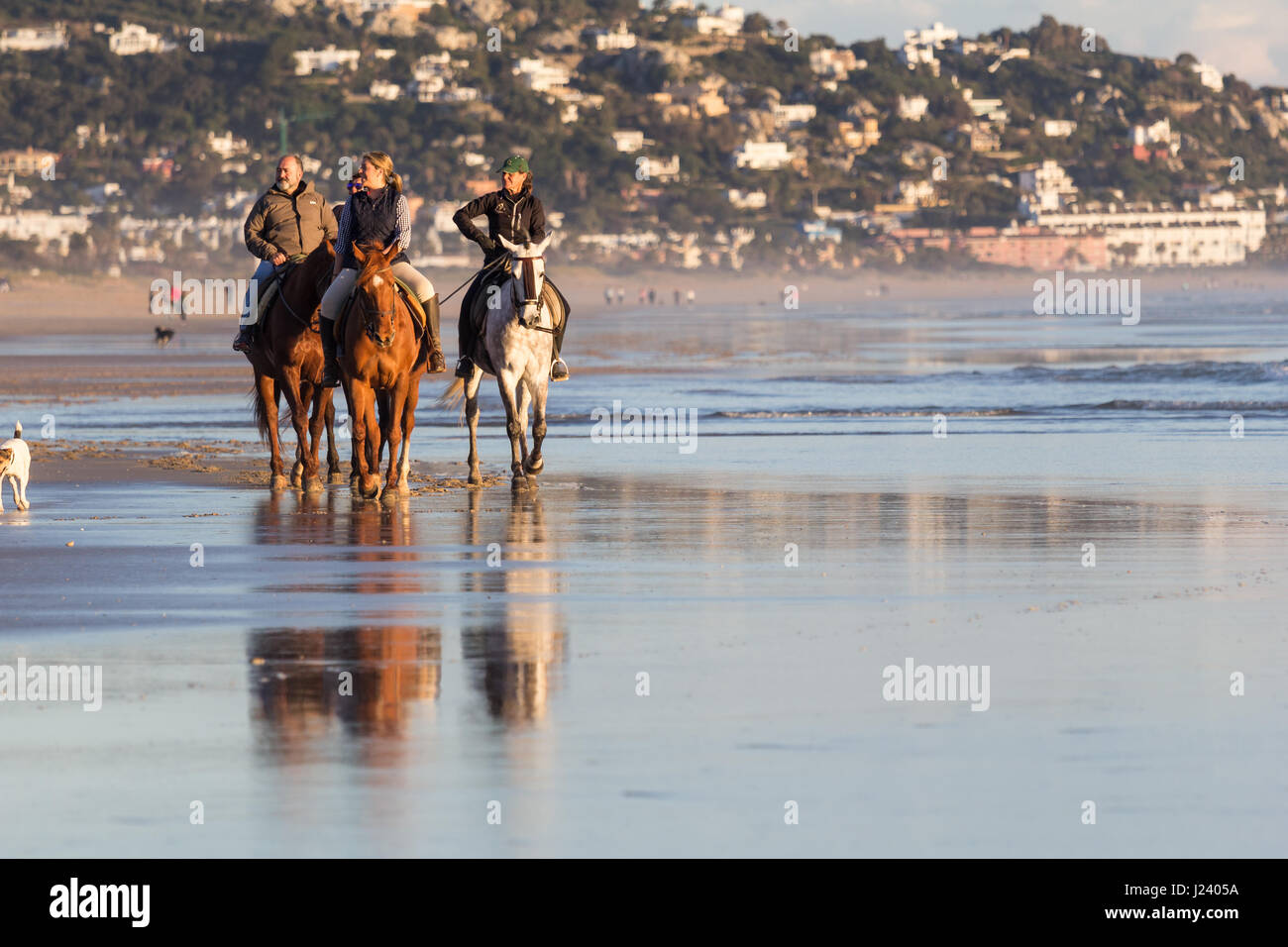 ZAHARA DE LOS ATUNES, CADIZ, SPAIN - MARCH 20, 2016: People having fun riding horses on the beach at Zahara de los Atunes, Cadiz, Andalusia, Spain Stock Photo