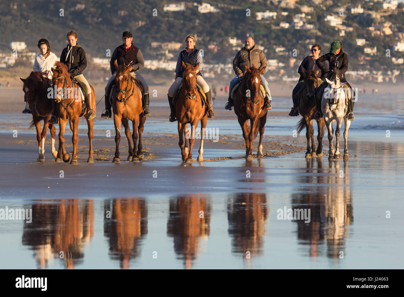 ZAHARA DE LOS ATUNES, CADIZ, SPAIN - MARCH 20, 2016: People having fun riding horses on the beach at Zahara de los Atunes, Cadiz, Andalusia, Spain Stock Photo