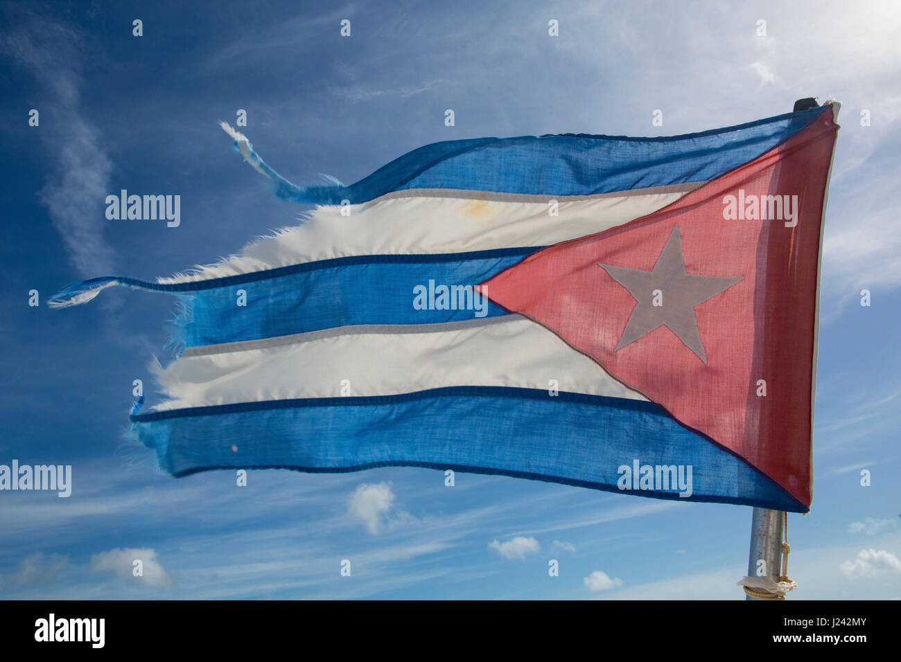 The Flag of Cuba, consisting of five strobes and a red equilateral triangle  with a white five-pointed star. Stock Photo