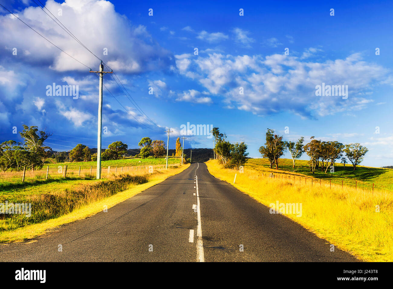 Country local road between grazing agricultural properties in Blue Mountains area on a sunny summer day. Remote location with little traffic 2 lanes s Stock Photo