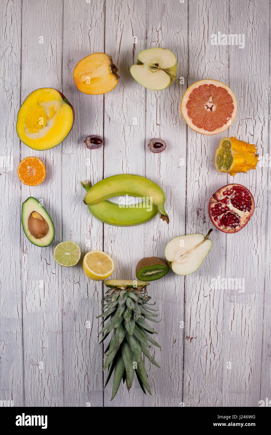 Assorted Halved Fruits Placed In A Circle Making A Shape Of A Face