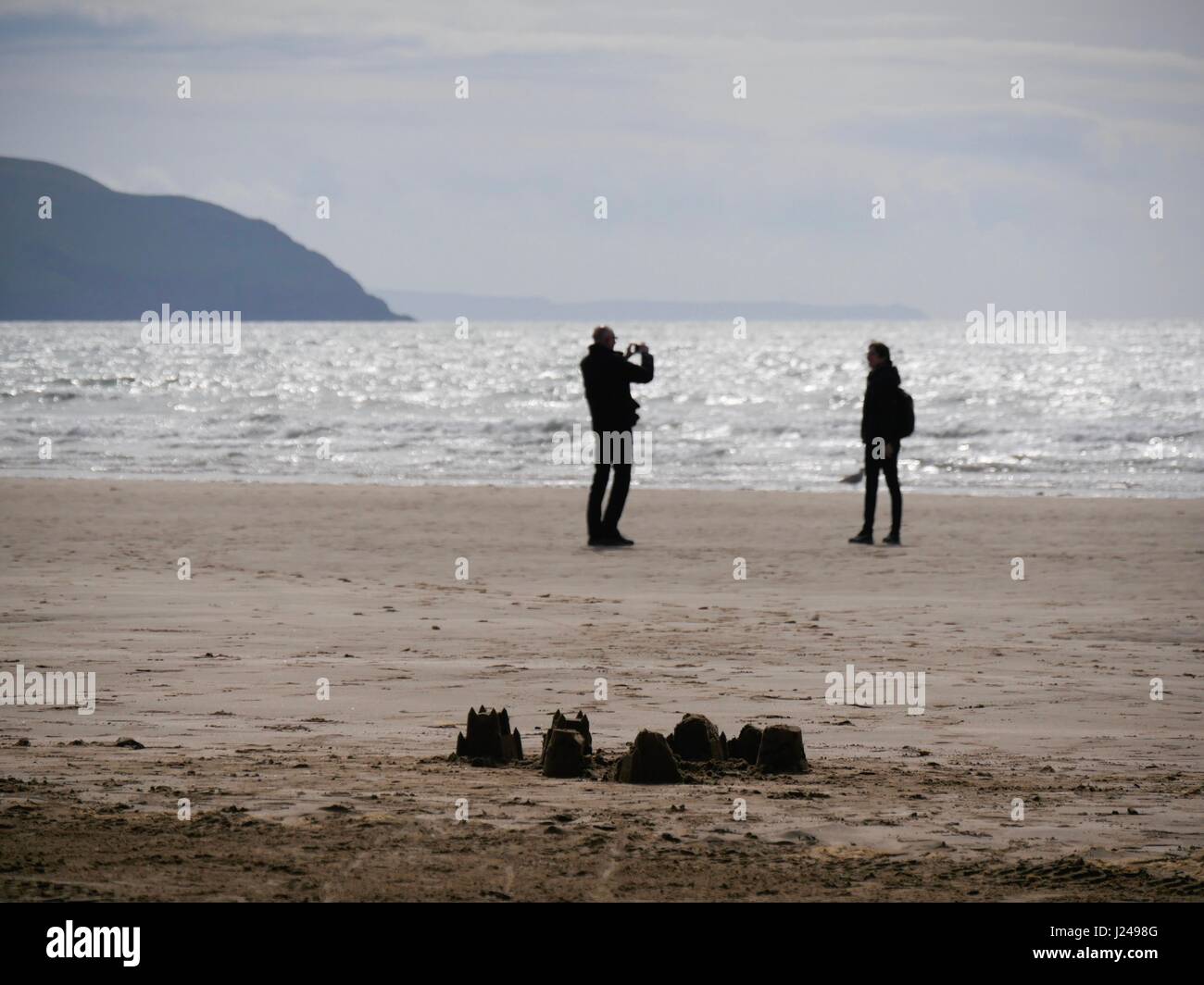 Woolacombe Beach, Devon, UK. 24th Apr, 2017. A person taking a picture of someone as sunny spells bring people out to this popular beach. Credit: DTNews/Alamy Live News Stock Photo