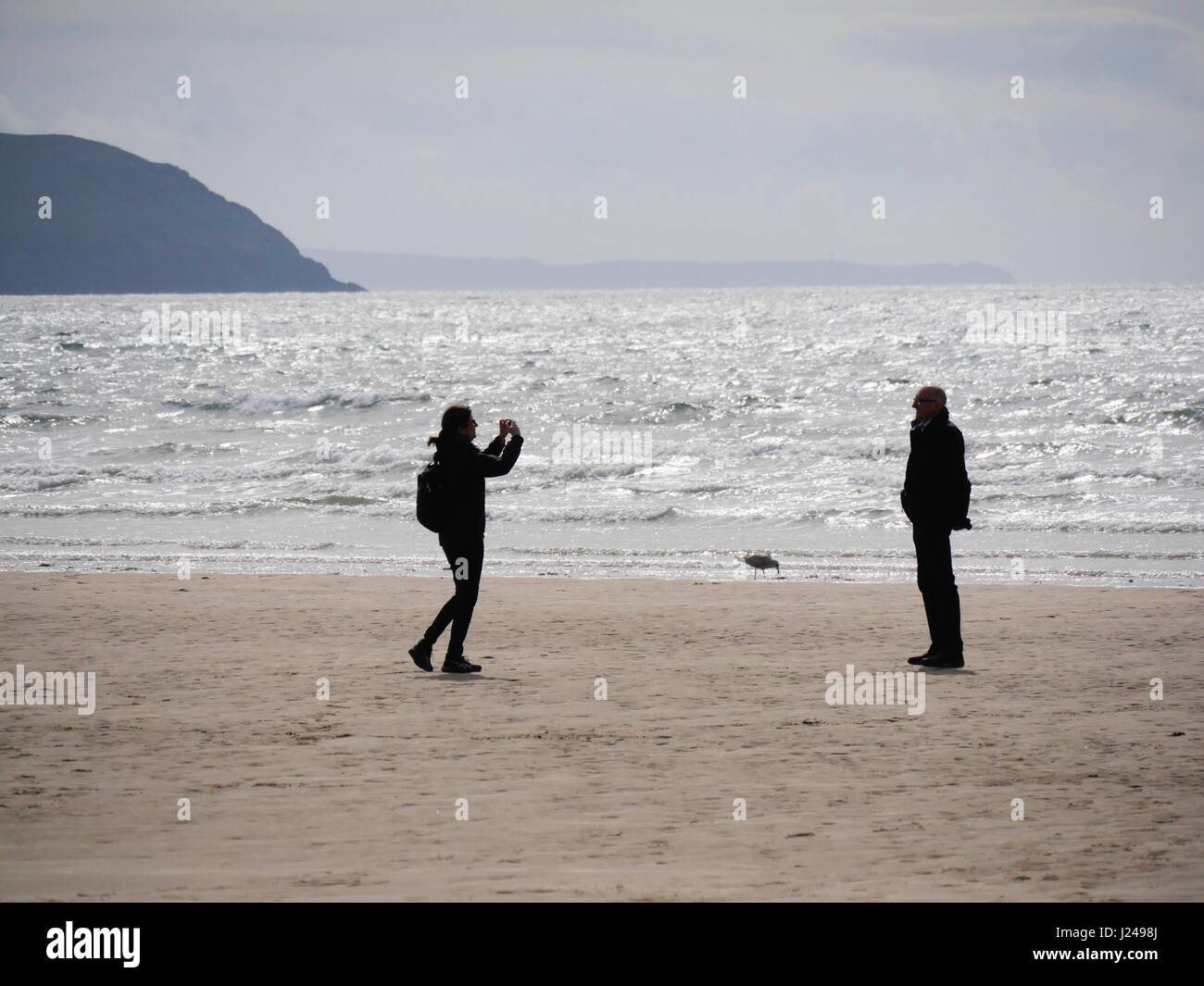 Woolacombe Beach, Devon, UK. 24th Apr, 2017. A person taking a picture of someone as sunny spells bring people out to this popular beach. Credit: DTNews/Alamy Live News Stock Photo