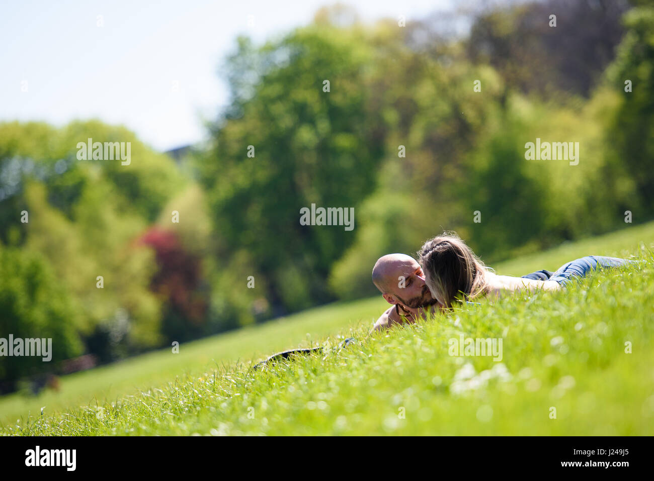 Munich, Germany. 24th Apr, 2017. A couple kisses in the English Garden in Munich, Germany, 24 April 2017. Photo: Florian Eckl/dpa/Alamy Live News Stock Photo