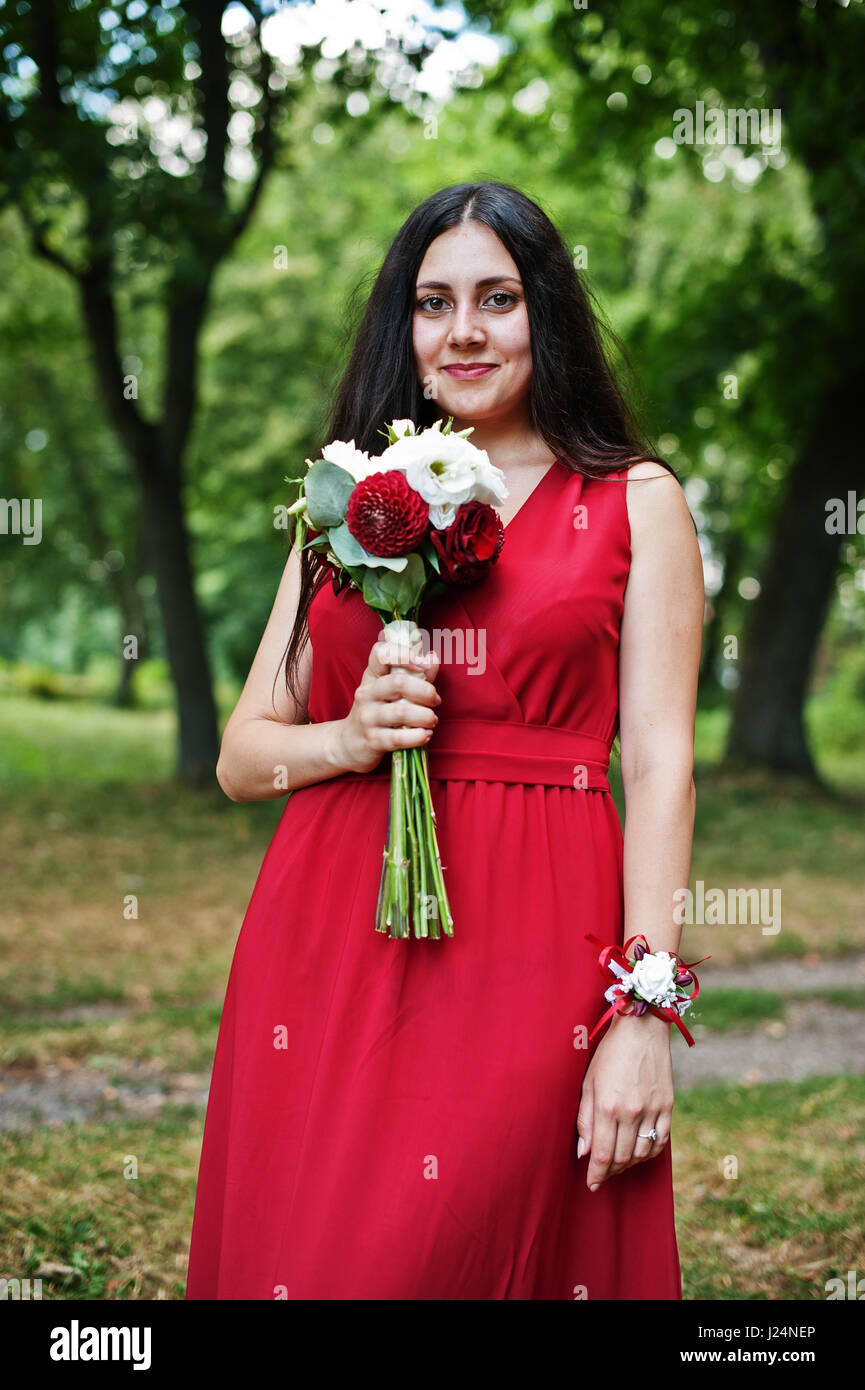 Cute girl bridesmaid at red dress with wedding bouquet at hand Stock ...