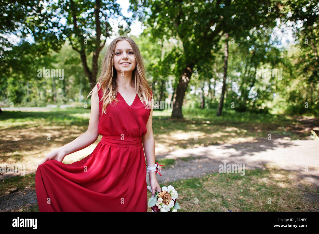 Cute girl bridesmaid at red dress with wedding bouquet at hand Stock ...