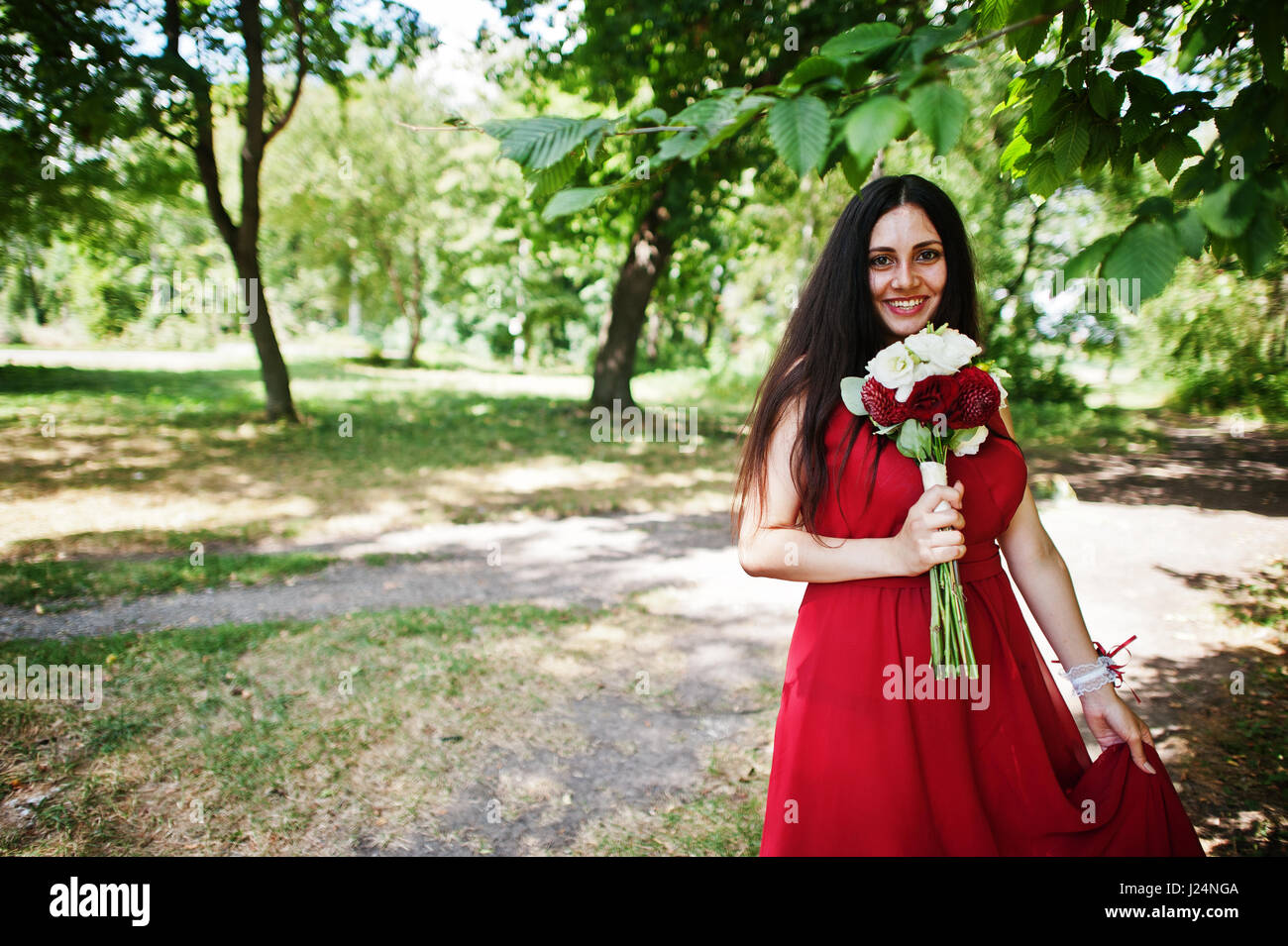 Cute girl bridesmaid at red dress with wedding bouquet at hand Stock ...