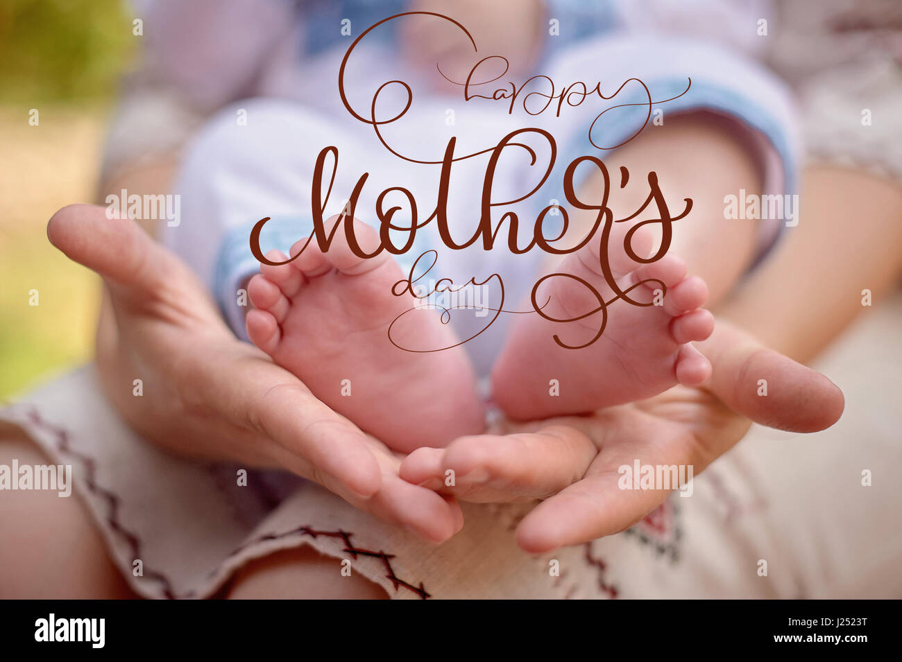 Mother hold the feet of her newborn son and Happy mothers day text. Calligraphy lettering hand draw Stock Photo